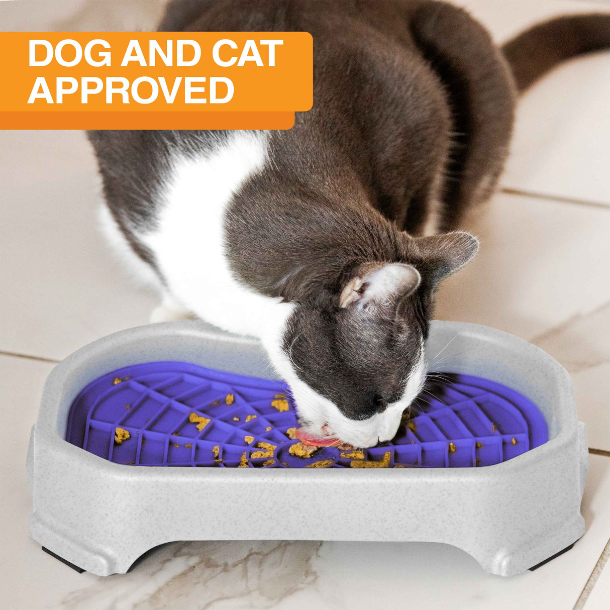 Cat licking food out of the Neat-Lik Mat Slow Feed Licking Mat with the base with text that says "Dog and cat approved."