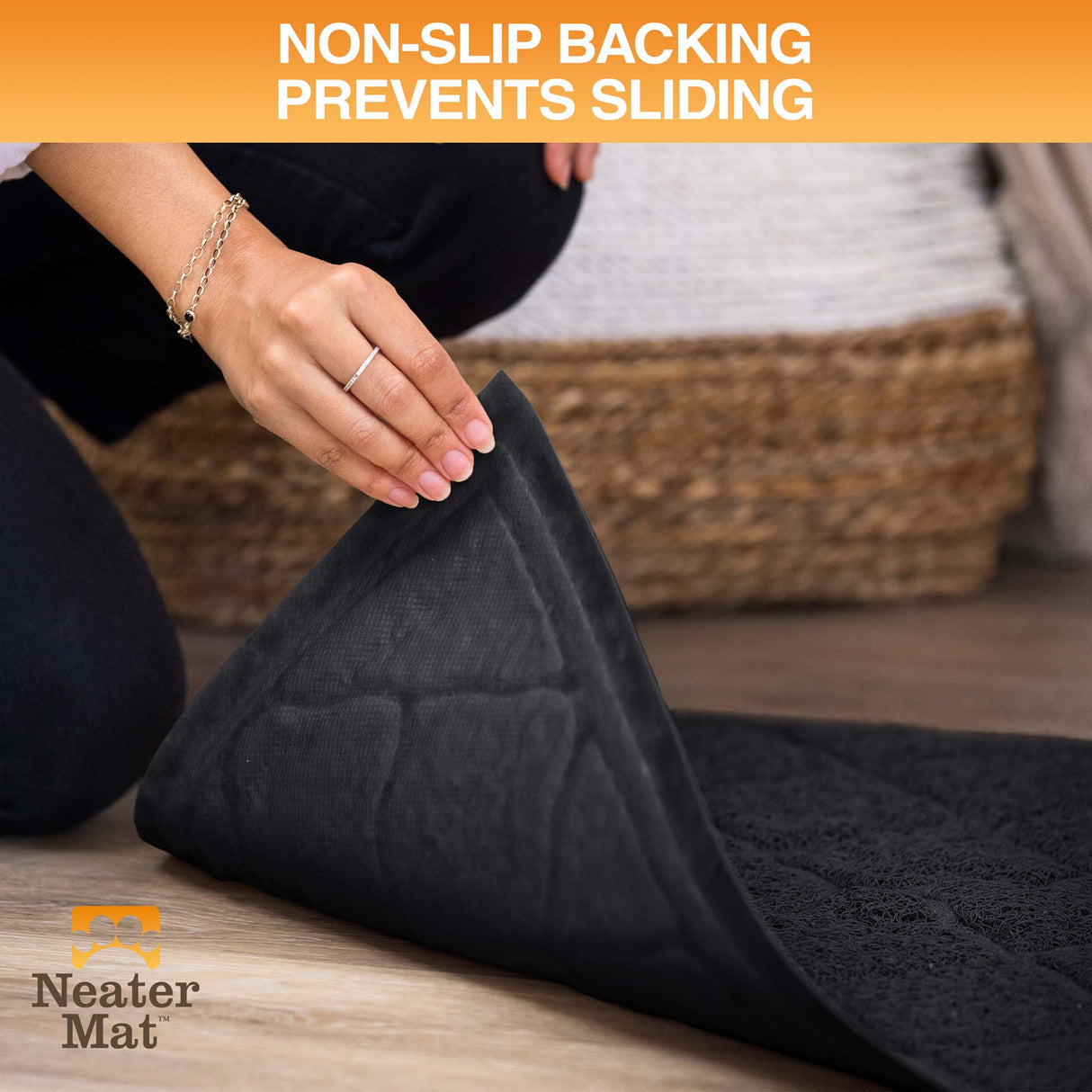 Black mat with non-slip backing being rolled out on a wooden floor, Neater Mat brand visible.