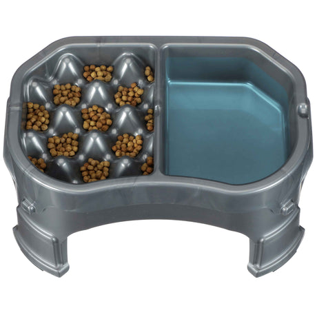 Raised Neater Slow Feeder Double Diner with kibble and water inside the feeder against a white background.