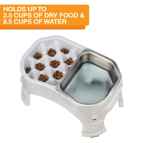 Neater Slow Feeder Double Diner with stainless steel insert with food and water inside the feeder against a white background. Text on the screen explains the food and water capacity.