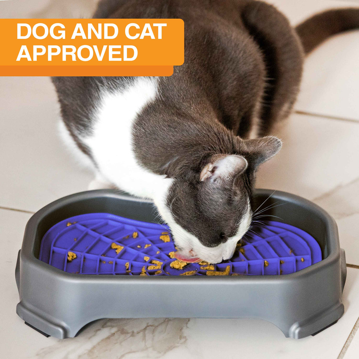 Cat licking food out of the Neat-Lik Mat Slow Feed Licking Mat with the base with text that says "Dog and cat approved."