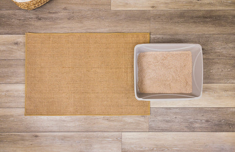A jute litter mat in front of a litter box.