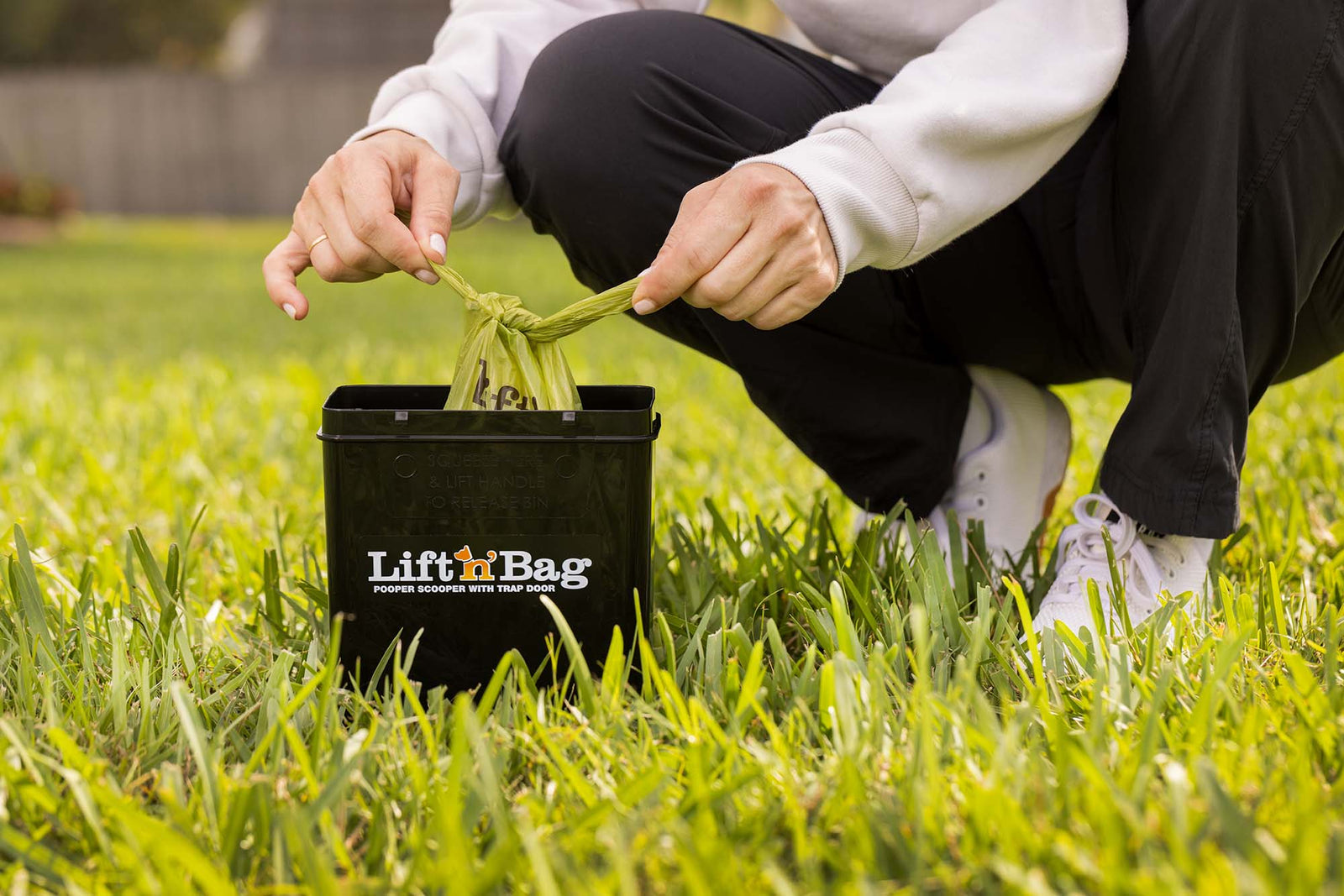 Image of person tying shut a Lift N Bag dog poop bag