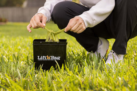 Image of person tying shut a Lift N Bag dog poop bag