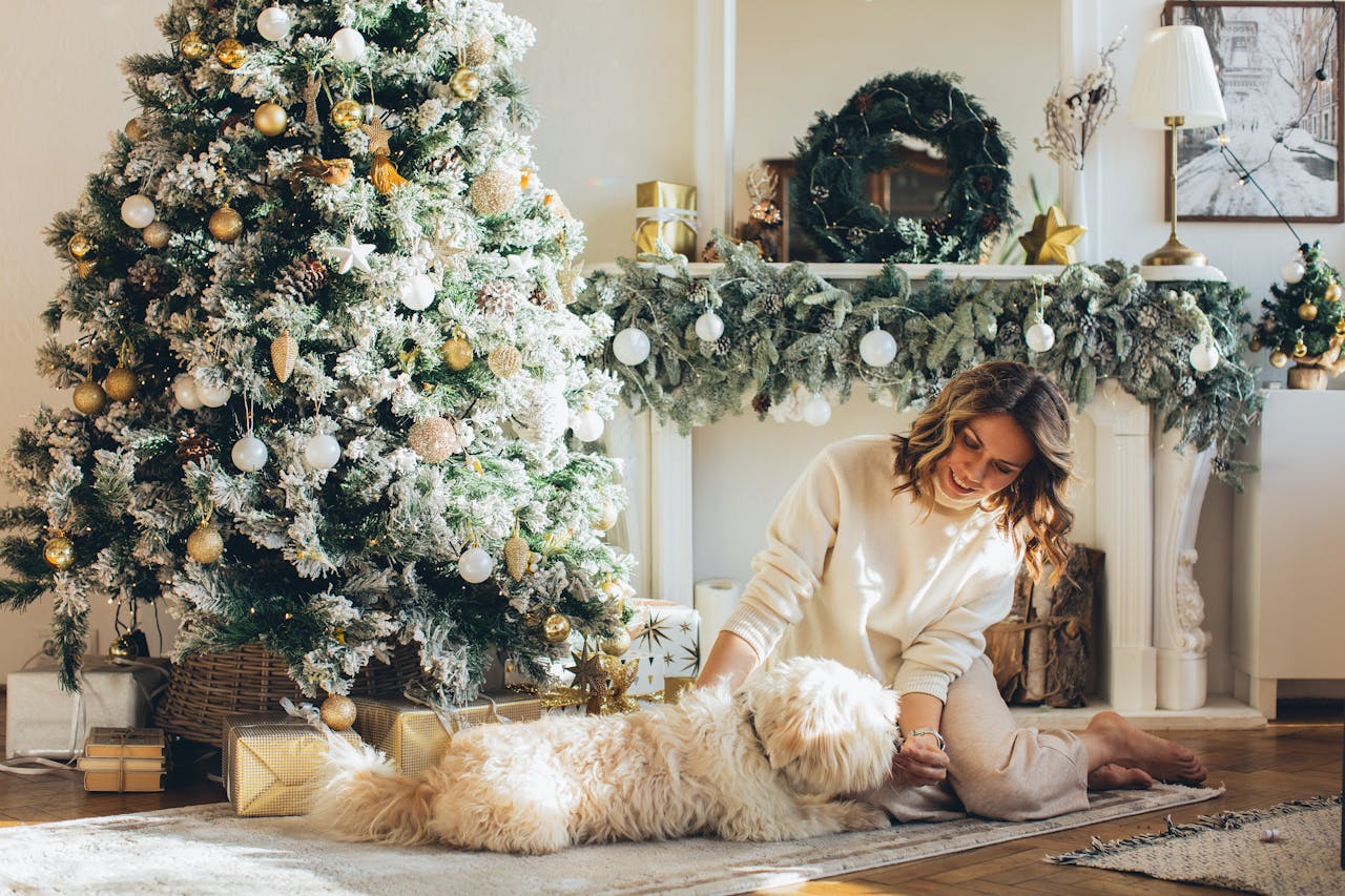 Woman and dog sitting in front of christmas tree