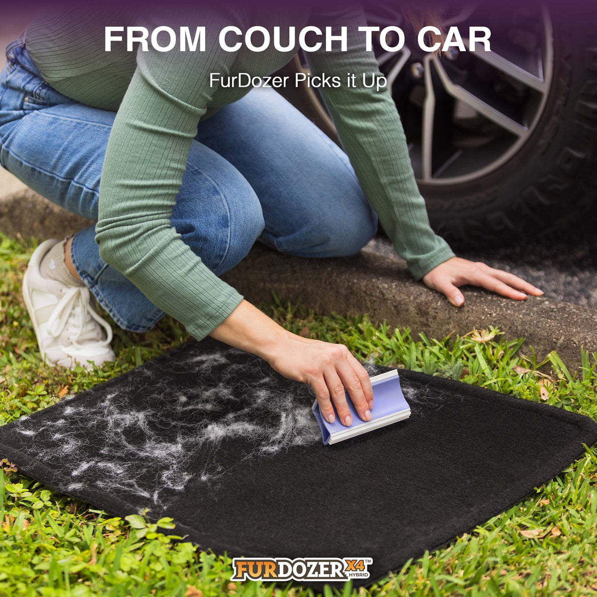 A person kneels on grass next to a car tire, using a FurDozer pet hair remover on a black car mat covered with white fur and debris. Text at the top reads 'FROM COUCH TO CAR FurDozer Picks it Up' and the FurDozer logo appears at the bottom.