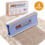 FurDozer X4 Pet Hair Remover and Lint Remover tool shown in front of its retail box on a beige shag rug with a streak of clean carpet under the FurDozer. There is an icon saying that it is a 2 pack. The FurDozer is a light purple/lavender color.