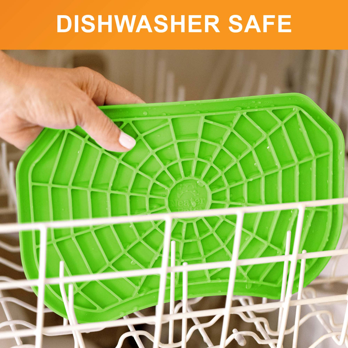 Dishwasher safe: a hand places the green Neat-Lik Express licking mat on the top rack of a dishwasher