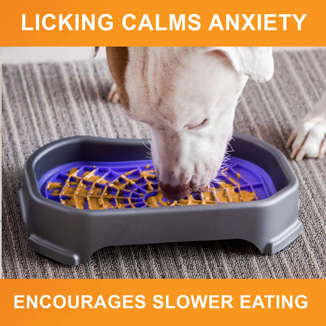 Dog licking peanut butter from the purple Neat-Lik Mat Slow Feed Licking Mat with text that reads "Encourages slow eating and reduces anxiety."