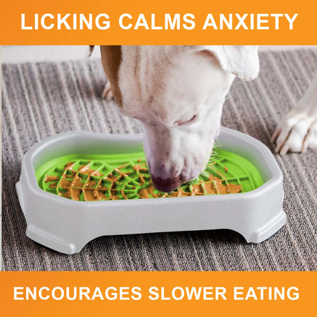 Dog licking peanut butter from the purple Neat-Lik Mat Slow Feed Licking Mat with text that reads "Encourages slow eating and reduces anxiety."