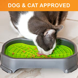 Cat licking food out of the Neat-Lik Mat Slow Feed Licking Mat with the base with text that says "Dog and cat approved."