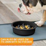 The Niner Slow Feed Bowl placed on a mat with a dog eating from it. The photo shows that it can be used on its own with no feeder.